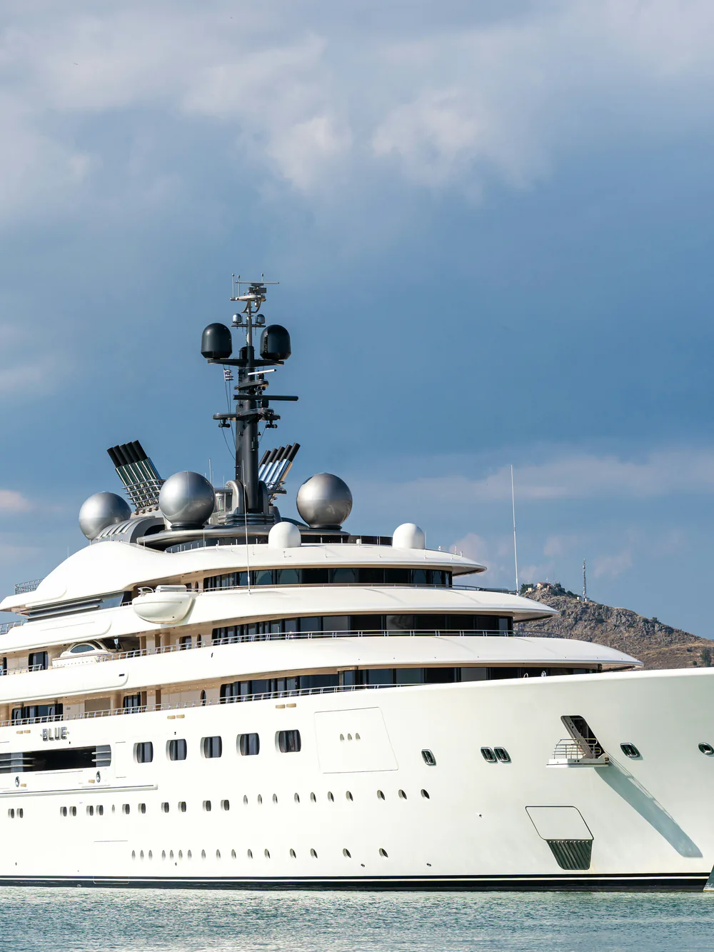 A superyacht moored in harbour under a big sky